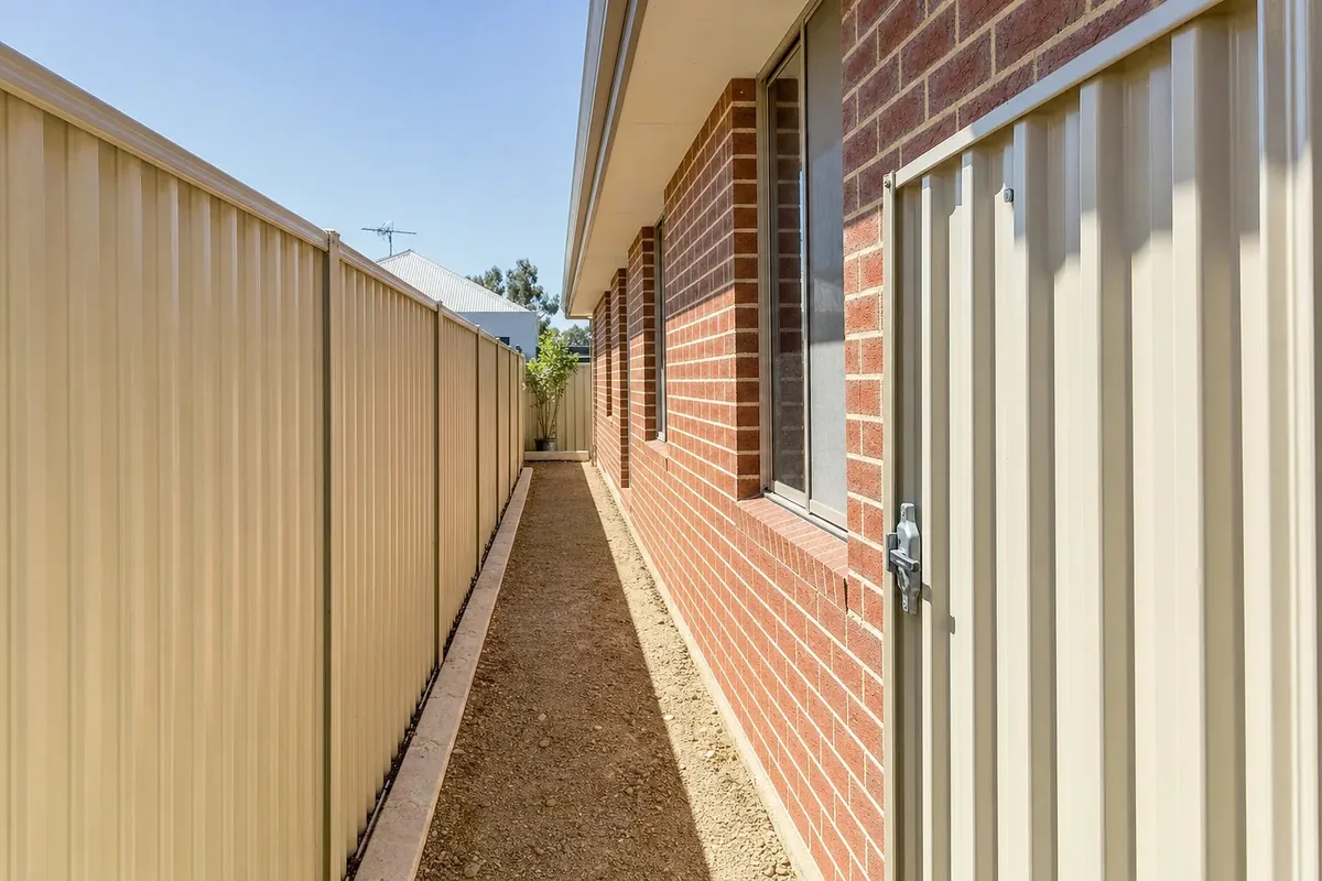 Narrow side access down a Perth block, showing the gate width and the ground a machine has to be loaded from