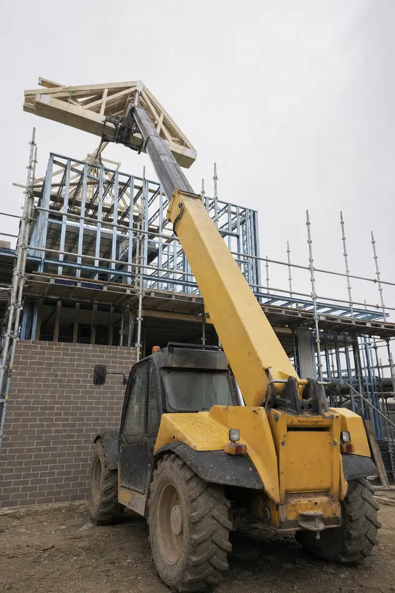 Telehandler placing a pack of roof trusses onto the first floor of a Perth house under construction